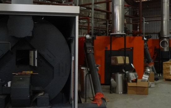 Three biomass boilers being installed in a shed Three biomass boilers being installed in a shed