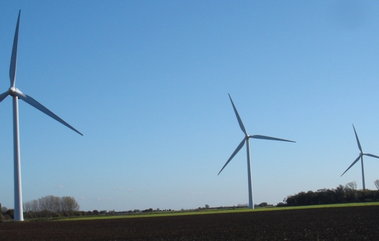 Four wind turbines in a field with blue sky Four wind turbines in a field with blue sky