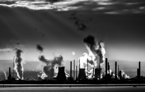 A black and white outline of a factory with smoke A black and white outline of a factory with smoke