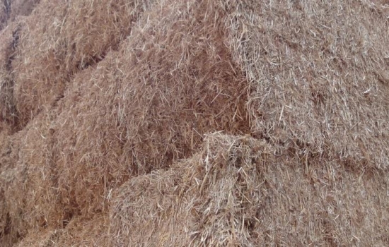 A close up of large straw bales stacked up