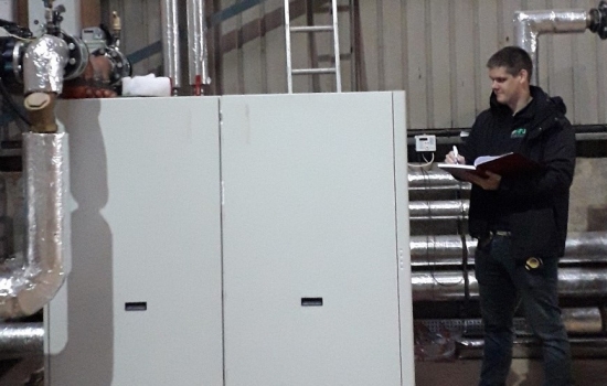 Person looking at machinery in a shed with pipework Person looking at machinery in a shed with pipework