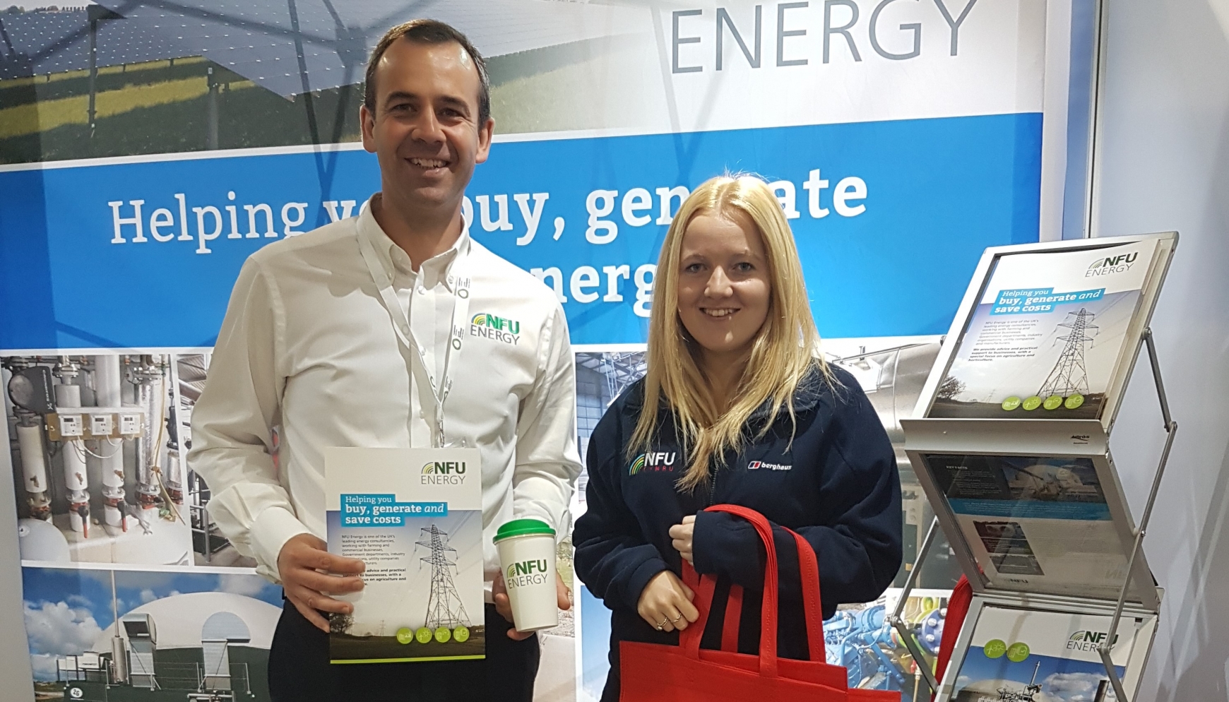 A man and a lady standing on an event stand at an expo