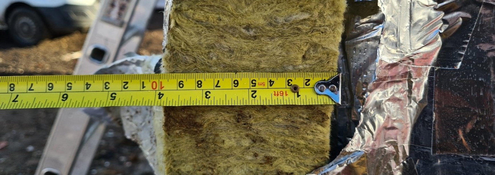 Tape measure measuring the thickness of insulation