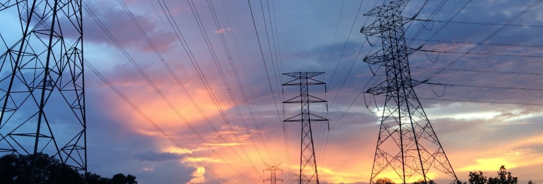 Electricity pylons with a sunset in the background