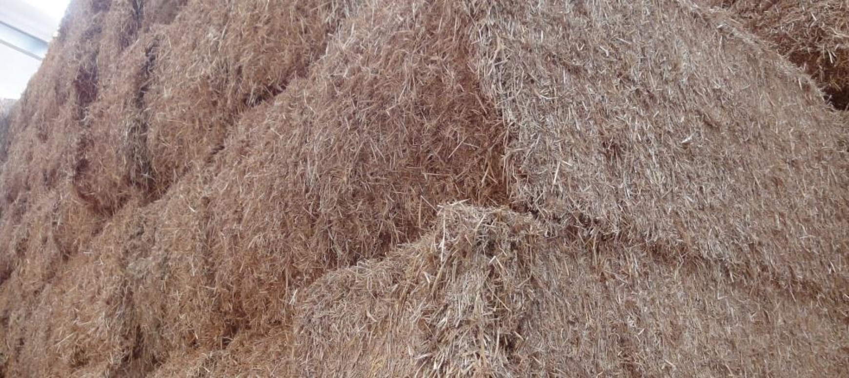 A close up of large straw bales stacked up