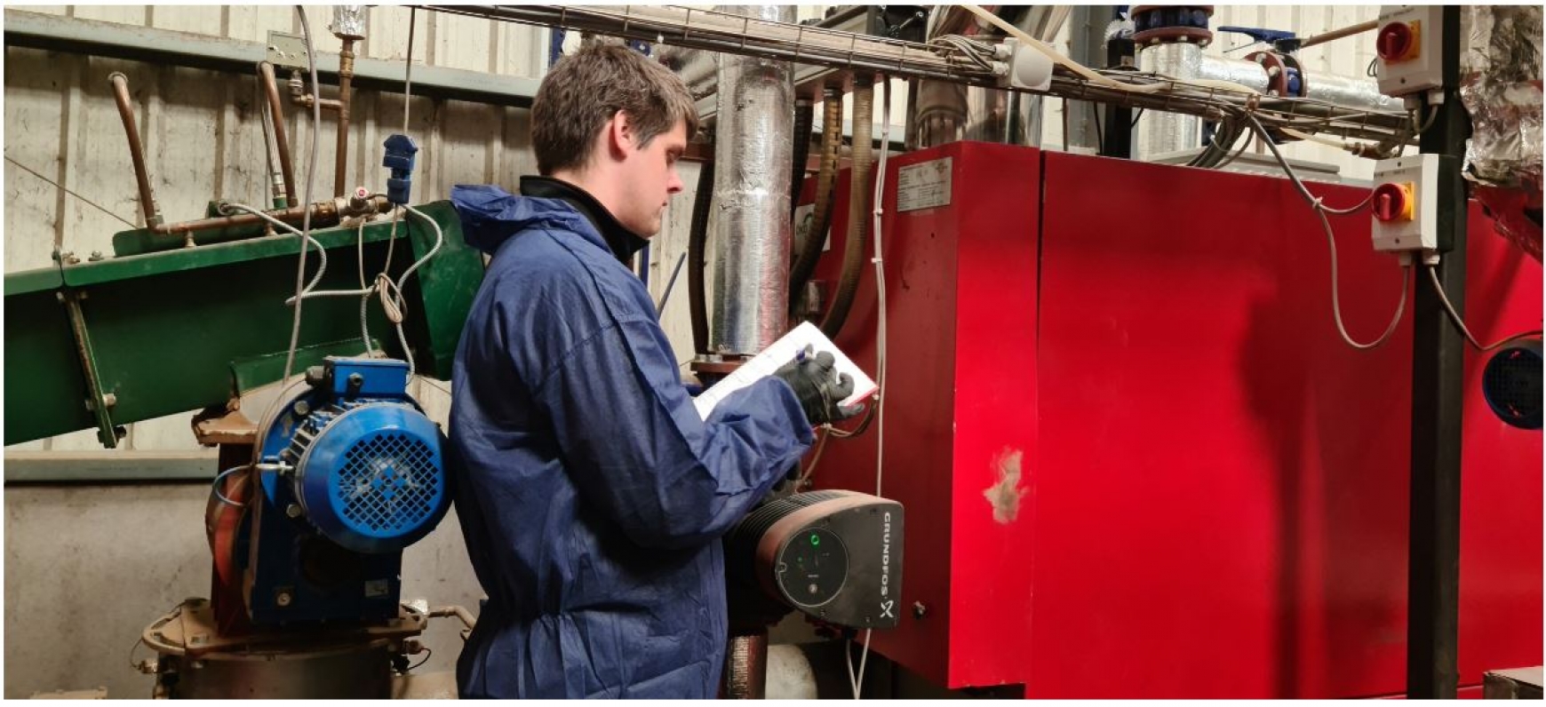 Engineer auditing pipework and machinery  
