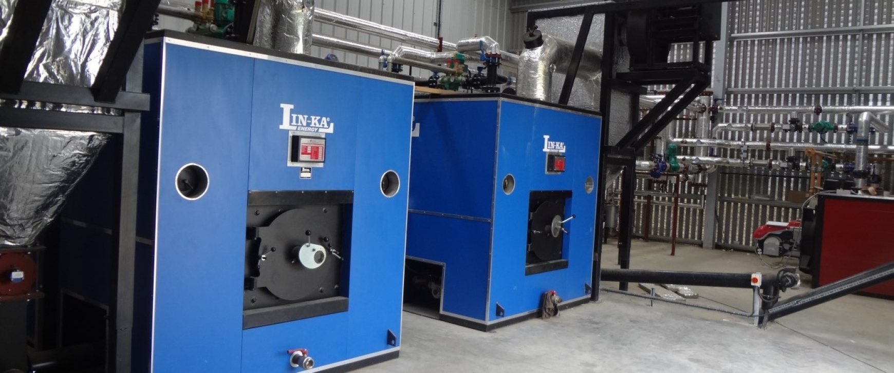 two blue biomass boilers in a shed