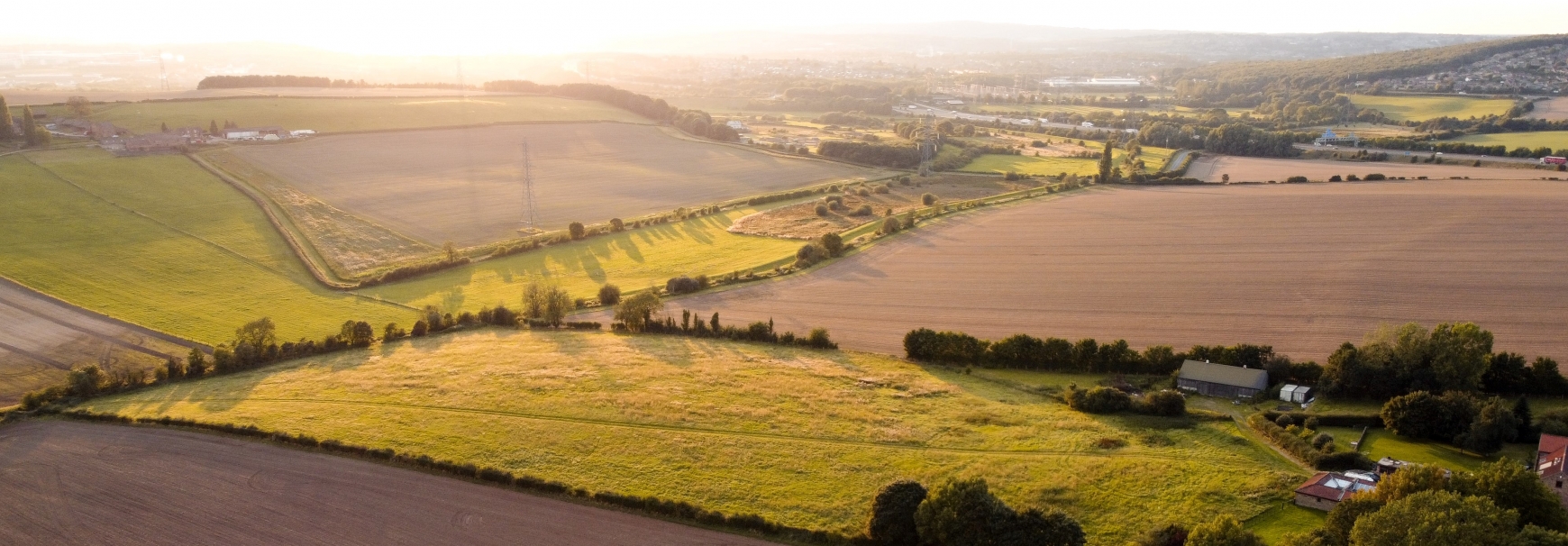 Rolling countryside fields with grass and crops