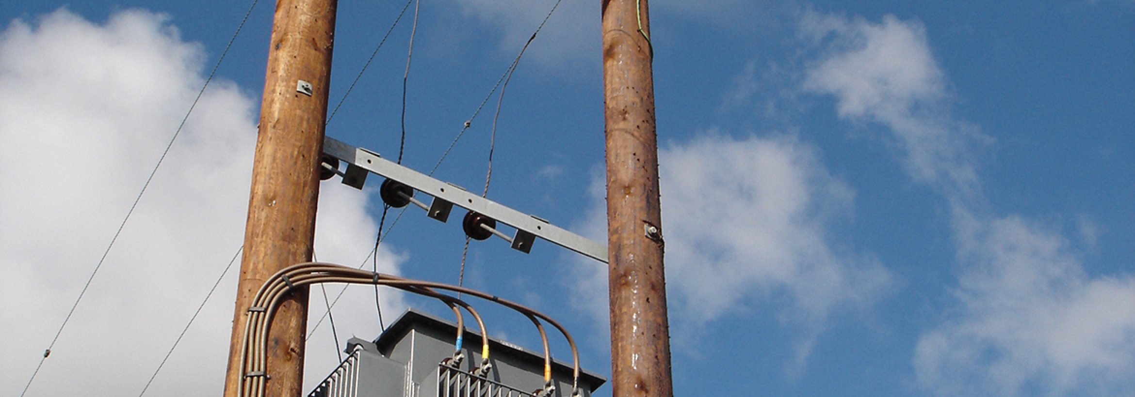 Electricity transformer on overhead poles representing NFU Energy's connections planning service