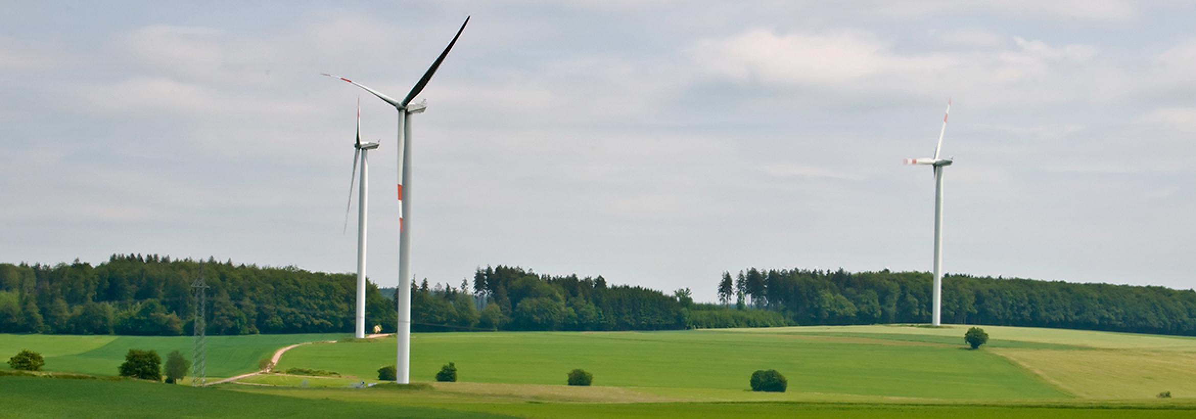 Wind turbines in the English countryside illustrating the opportunity to selling energy generated back to the grid with NFU Energy's help